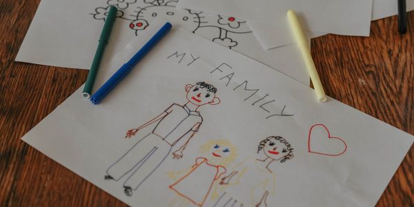 A hand-drawn family portrait using colored markers on paper, showcasing creativity and love.