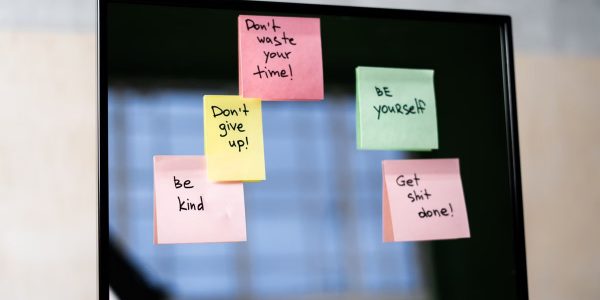 Colorful sticky notes on a mirror provide daily motivational messages and positivity reminders.